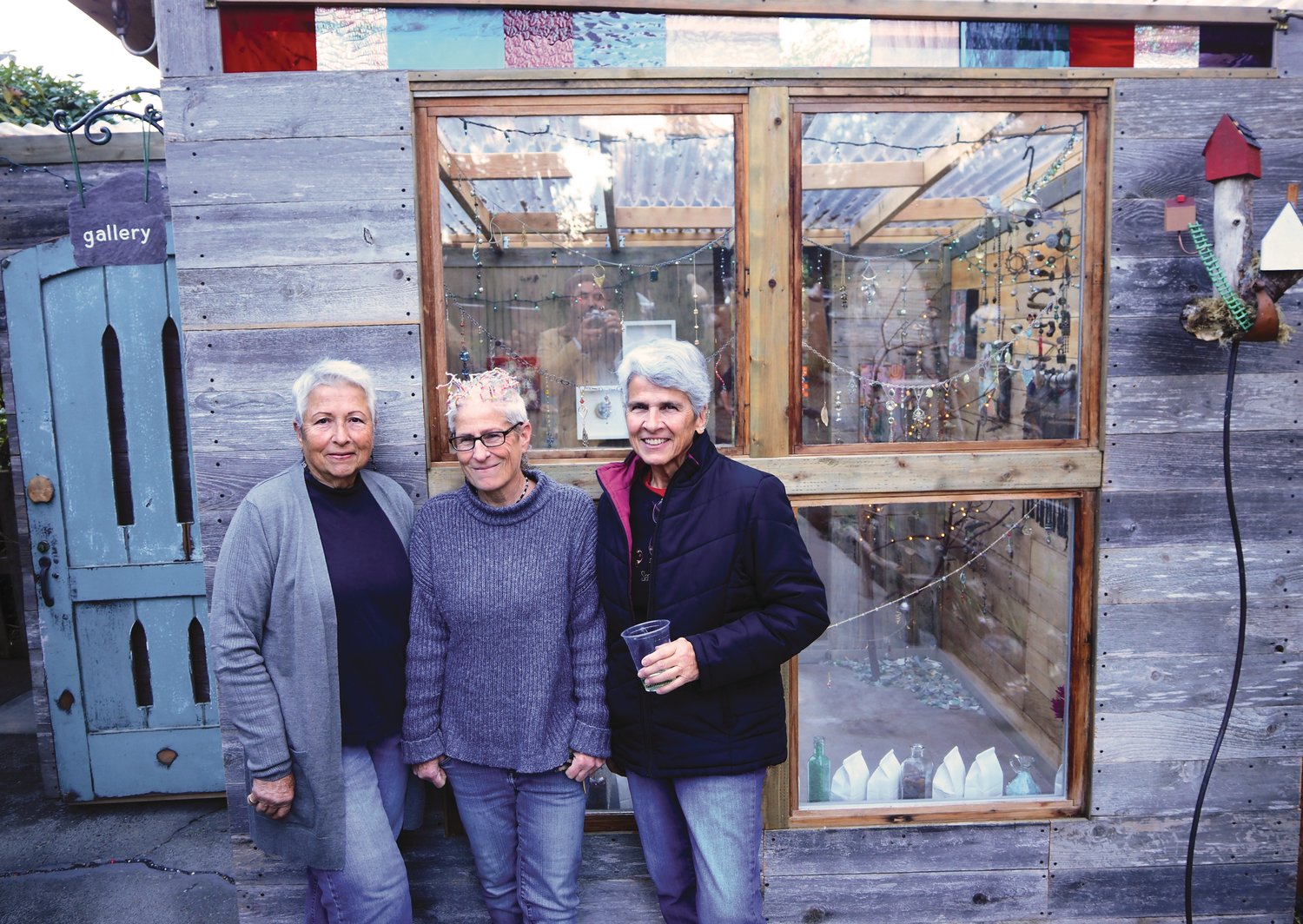 Carol Nicosia-Whelan, DJ Whelan, and Pat Nicosia are the mother, daughter, aunt team that built the gallery structure behind them to help build community in their new home.